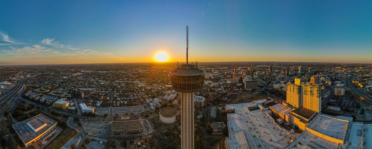 a panoramic drone image showing the Tower of the Americas in downtown San Antonio at Sunset